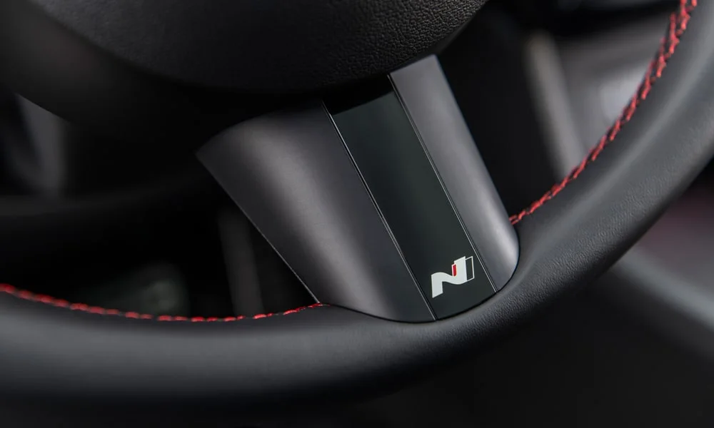 Фото Hyundai Tucson N Line (2024) — руль. Обшивка обода и компоновка спиц крупным планом. Клавиши на спицах управляют медиа, круизом и ассистентами — руки остаются на руле Hyundai Tucson N Line (2024) — руль