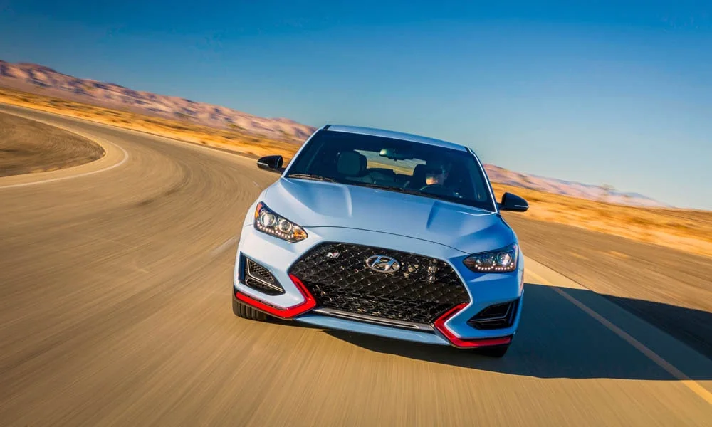 Фото Hyundai Veloster N (2024) — вид спереди, фото 7. Оптика, решётка и бампер — первое впечатление о модели. Рисунок ходовых огней — подпись модели, по нему её узнают в потоке Hyundai Veloster N (2024) — вид спереди, фото 7