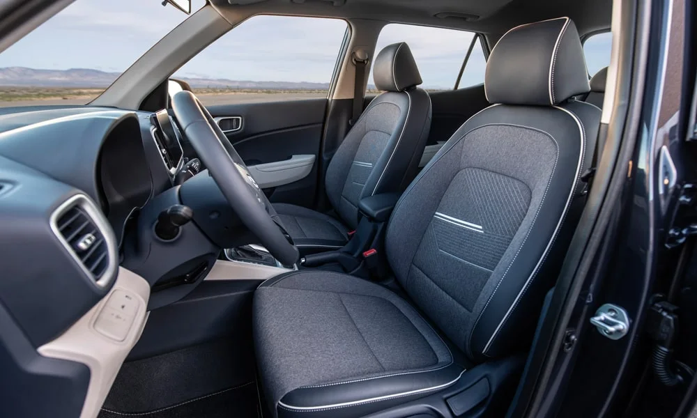Фото Hyundai Venue — интерьер. Общий план салона: архитектура панели, консоль и кресла. Светлая гамма зрительно расширяет салон, тёмная — практичнее в уходе Hyundai Venue — интерьер