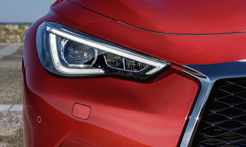 Фото Infiniti Q60 — вид спереди, фото 4. Красный кузов, строгая симметрия оптики — базовый ракурс знакомства с дизайном. Дневные ходовые огни включаются автоматически с запуском Infiniti Q60 — вид спереди, фото 4