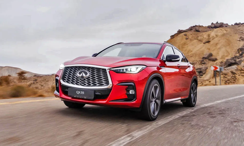 Фото Infiniti QX55 — вид спереди, фото 10. Кузов в красном цвете: рисунок оптики и решётки задаёт узнаваемое «лицо» модели. Дневные ходовые огни включаются автоматически с запуском Infiniti QX55 — вид спереди, фото 10