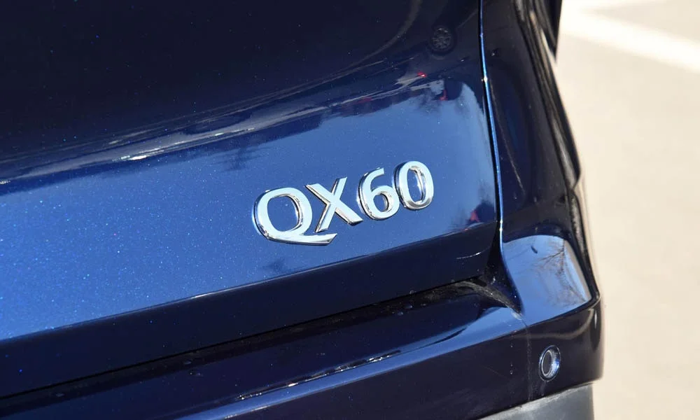 Фото Infiniti QX60 (2024) — эмблема. Логотип марки крупным планом Infiniti QX60 (2024) — эмблема
