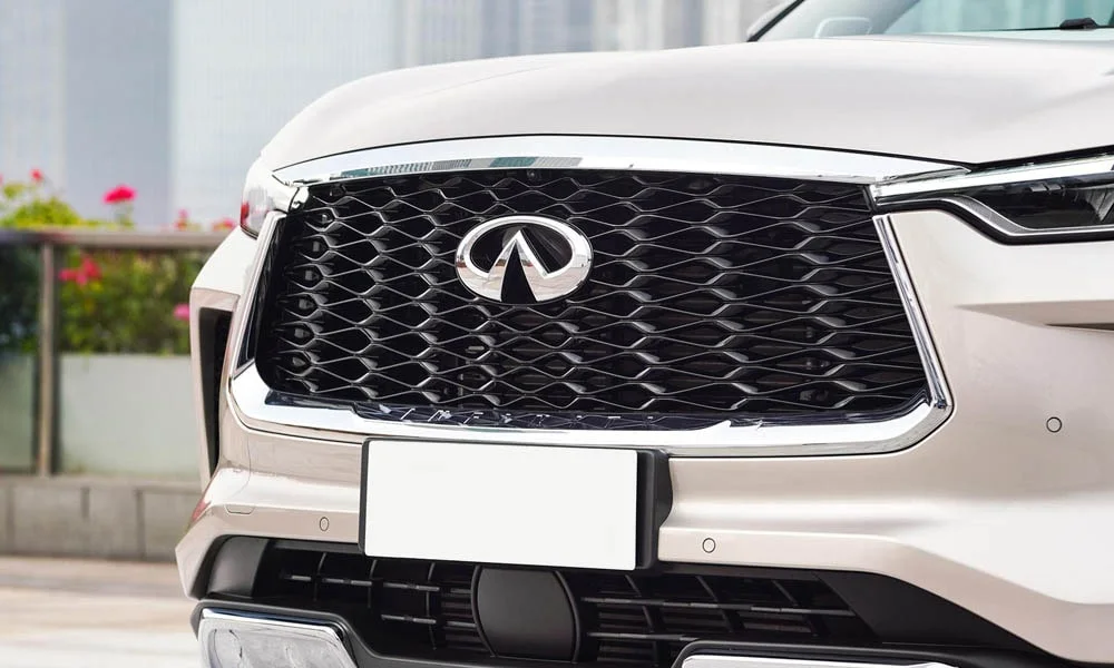 Фото Infiniti QX60 (2024) — решётка радиатора. Фирменный рисунок облицовки — визитная карточка марки. За решёткой у многих комплектаций стоит радар адаптивного круиз-контроля Infiniti QX60 (2024) — решётка радиатора