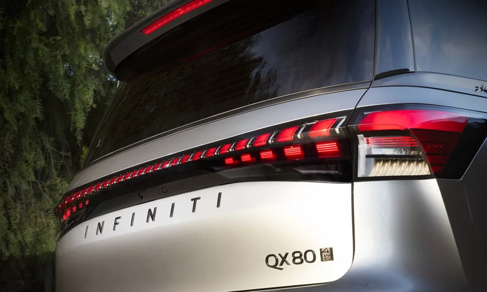 Фото Infiniti QX80 (2024) — вид сзади, фото 4. Графика фонарей, бампер и оформление пятой двери. Насадки выхлопа или их имитация внизу бампера различают версии Infiniti QX80 (2024) — вид сзади, фото 4