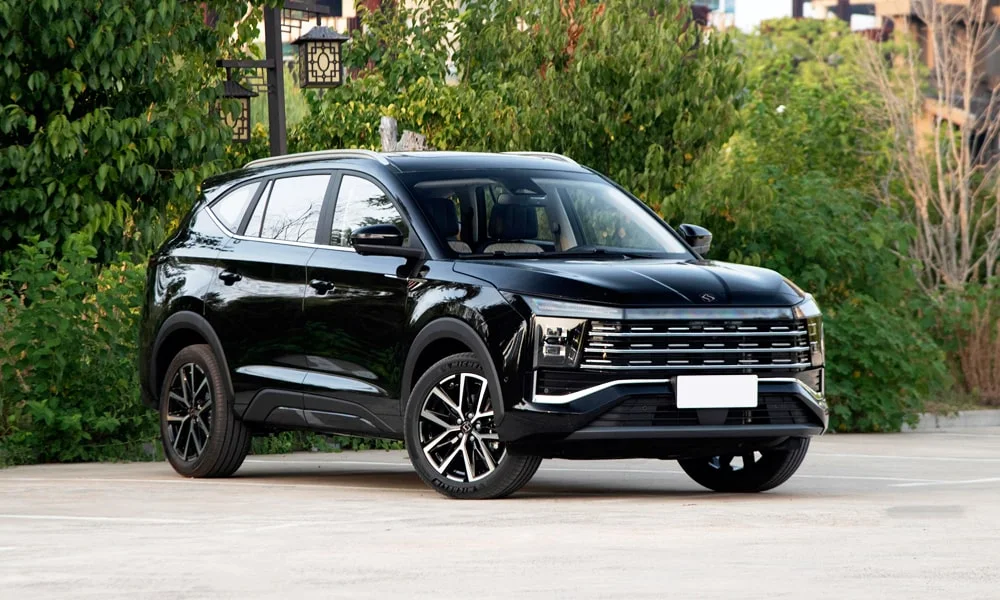 Фото JAC X8 Plus (2024) — вид спереди, фото 3. Кузов в чёрном цвете: рисунок оптики и решётки задаёт узнаваемое «лицо» модели. Рисунок ходовых огней — подпись модели, по нему её узнают в потоке JAC X8 Plus (2024) — вид спереди, фото 3
