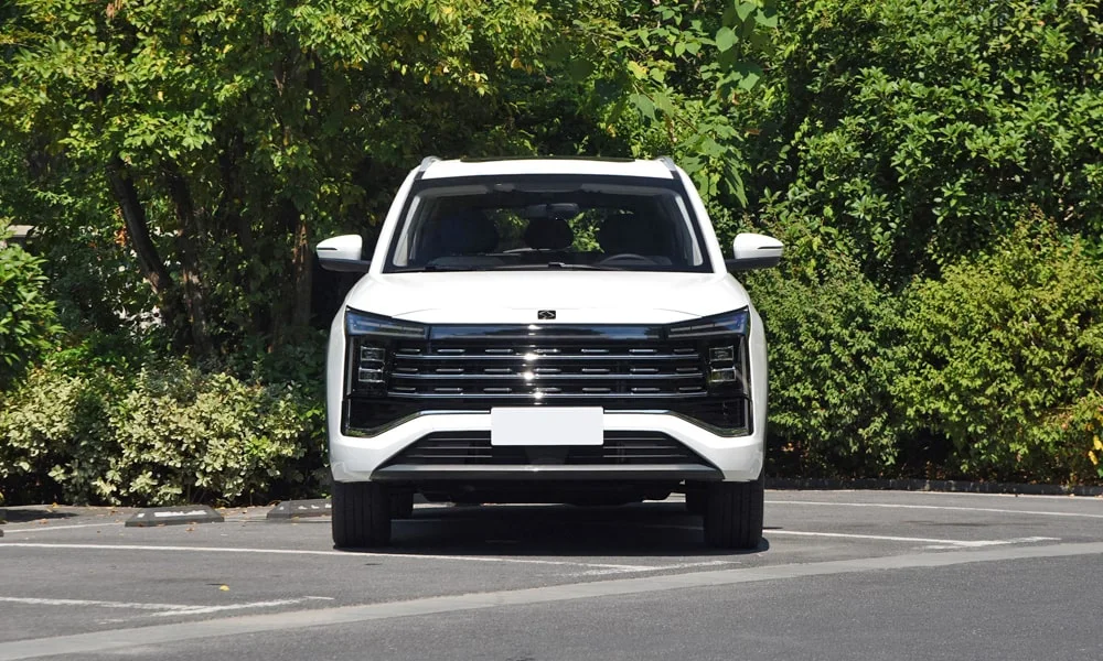 Фото JAC X8 Plus (2024) — вид спереди, фото 4. Кузов в белом цвете: рисунок оптики и решётки задаёт узнаваемое «лицо» модели JAC X8 Plus (2024) — вид спереди, фото 4