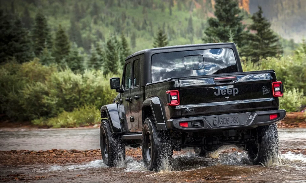 Фото Jeep Gladiator (2024) — вид сзади, фото 7. Чёрный кузов сзади — фонари и бампер определяют ночной образ модели. Насадки выхлопа или их имитация внизу бампера различают версии Jeep Gladiator (2024) — вид сзади, фото 7