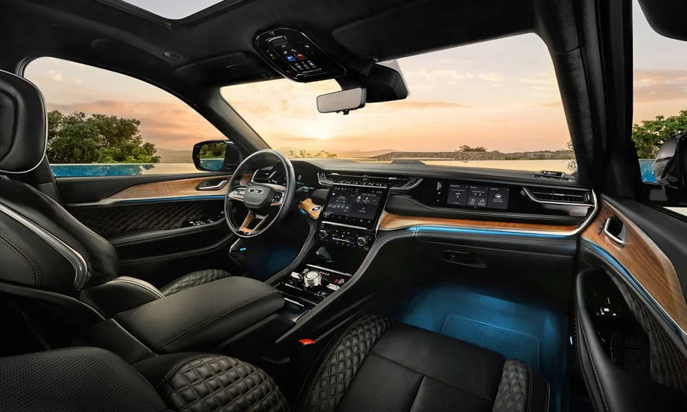 Фото Jeep Grand Cherokee (2024) — интерьер. Салон в тёмно-синей отделке: архитектура передней панели, консоль и кресла Jeep Grand Cherokee (2024) — интерьер