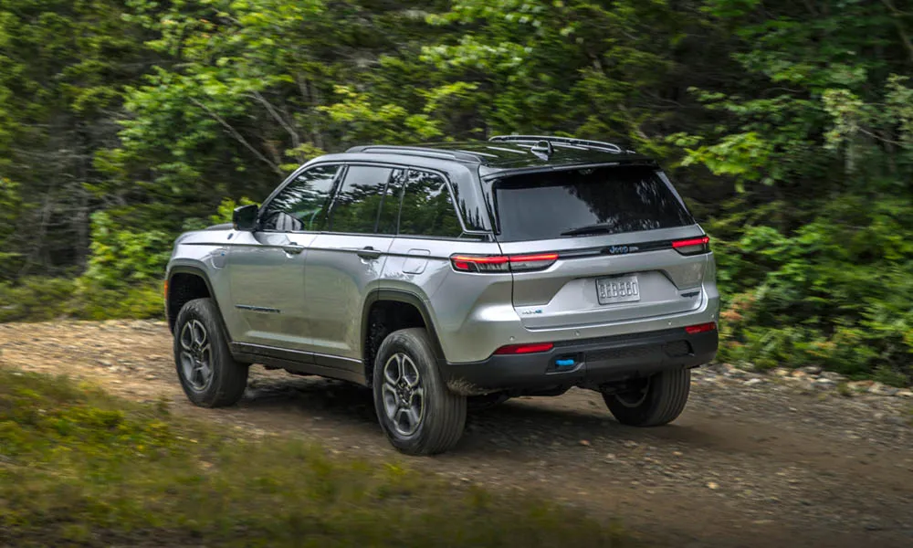 Фото Jeep Grand Cherokee (2024) — вид сзади, фото 7. Линия крыши, стойки и задняя дверь в сером исполнении. Насадки выхлопа или их имитация внизу бампера различают версии Jeep Grand Cherokee (2024) — вид сзади, фото 7