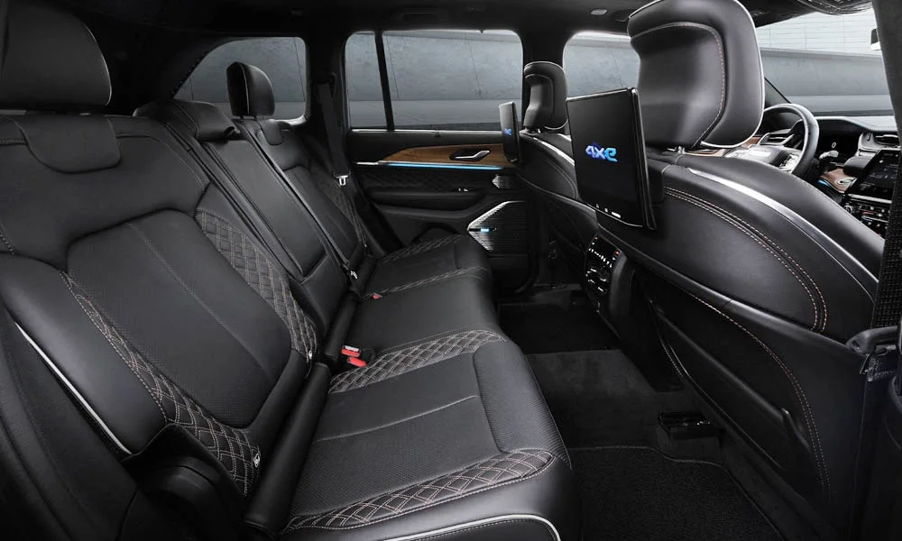Фото Jeep Grand Cherokee (2024) — задние сиденья. Второй ряд: профиль дивана, подголовники и обивка из перфорированной коже. Плоский пол упрощает посадку втроём Jeep Grand Cherokee (2024) — задние сиденья
