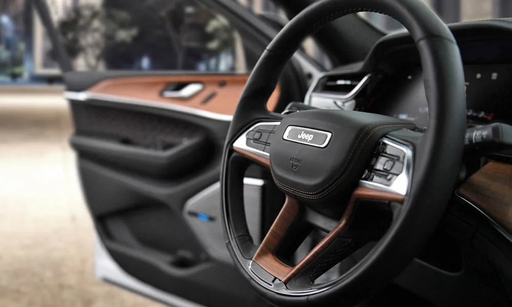 Фото Jeep Grand Cherokee (2024) — руль. Обшивка обода и компоновка спиц крупным планом. Клавиши на спицах управляют медиа, круизом и ассистентами — руки остаются на руле Jeep Grand Cherokee (2024) — руль
