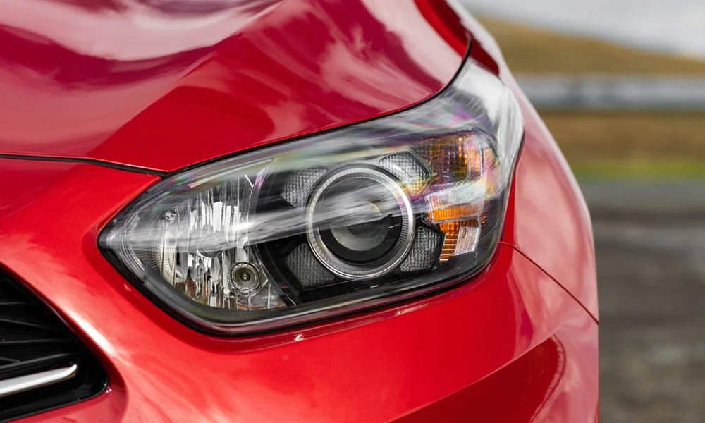 Фото KIA Ceed SW — вид спереди, фото 5. Передок в красном исполнении — крупная светотехника и выразительный бампер. Дневные ходовые огни включаются автоматически с запуском KIA Ceed SW — вид спереди, фото 5