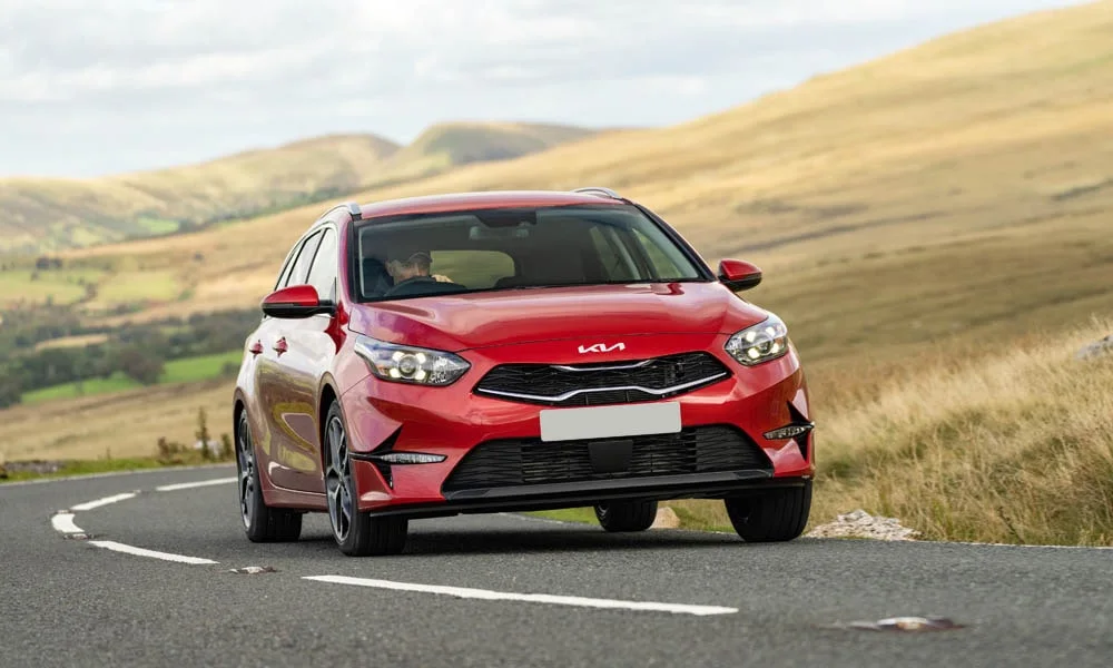 Фото KIA Ceed SW — вид спереди, фото 7. Кузов в красном цвете: рисунок оптики и решётки задаёт узнаваемое «лицо» модели KIA Ceed SW — вид спереди, фото 7