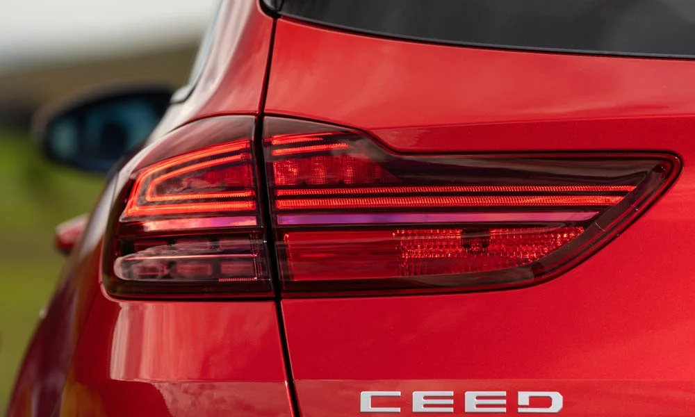 Фото KIA Ceed SW — вид сзади, фото 3. Красный кузов сзади — фонари и бампер определяют ночной образ модели KIA Ceed SW — вид сзади, фото 3