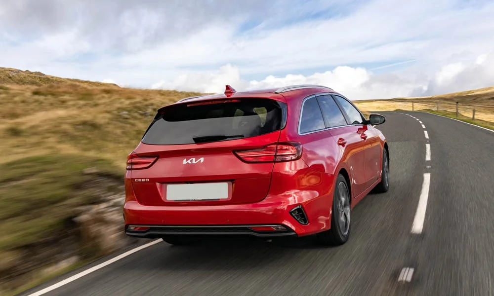 Фото KIA Ceed SW — вид сзади, фото 4. Корма в красном цвете: графика фонарей и пластика пятой двери. Насадки выхлопа или их имитация внизу бампера различают версии KIA Ceed SW — вид сзади, фото 4
