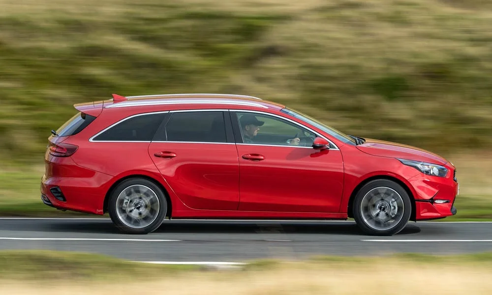Фото KIA Ceed SW — вид сбоку, фото 3. Сбоку читаются линия остекления и характер выштамповок на красном кузове. Длинная база — простор второго ряда; короткие свесы упрощают парковку KIA Ceed SW — вид сбоку, фото 3