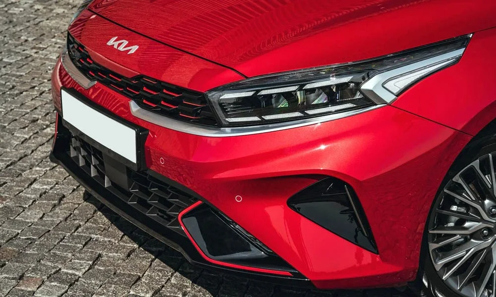 Фото KIA Cerato — вид спереди, фото 6. Красный кузов, строгая симметрия оптики — базовый ракурс знакомства с дизайном. Рисунок ходовых огней — подпись модели, по нему её узнают в потоке KIA Cerato — вид спереди, фото 6