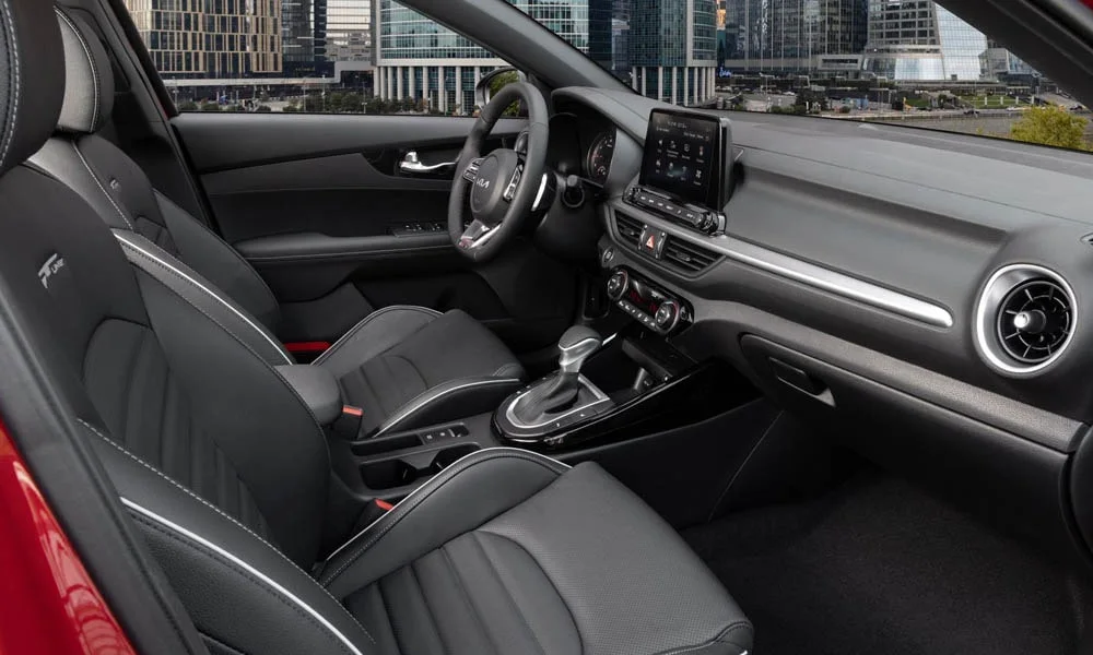 Фото KIA Cerato — интерьер. Салон в красно-чёрной отделке: архитектура передней панели, консоль и кресла KIA Cerato — интерьер
