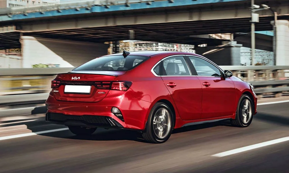 Фото KIA Cerato — вид сзади, фото 11. Корма в красном цвете: графика фонарей и пластика пятой двери. Насадки выхлопа или их имитация внизу бампера различают версии KIA Cerato — вид сзади, фото 11
