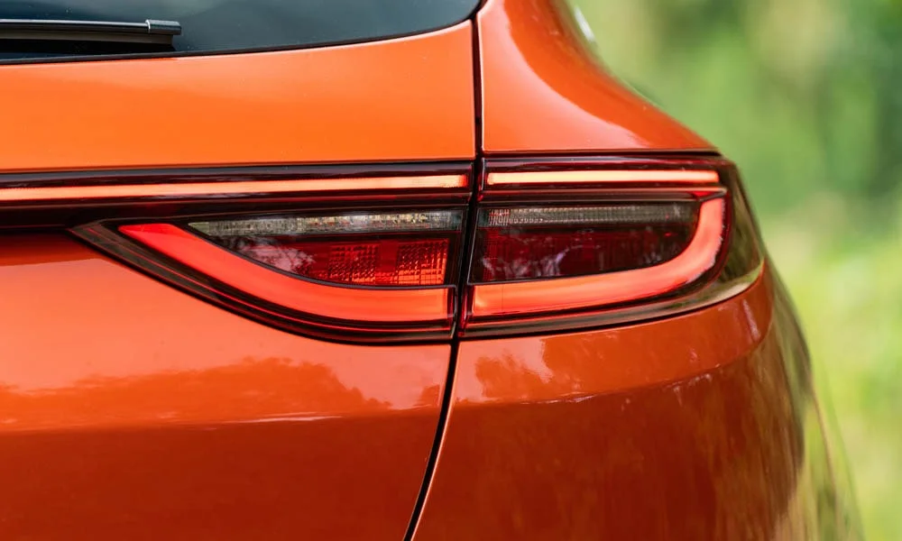 Фото KIA ProCeed (2024) — вид сзади, фото 3. Корма в оранжевом цвете: графика фонарей и пластика пятой двери. Светодиодная полоса или раздельные секции — задняя оптика стала главным украшением кормы KIA ProCeed (2024) — вид сзади, фото 3