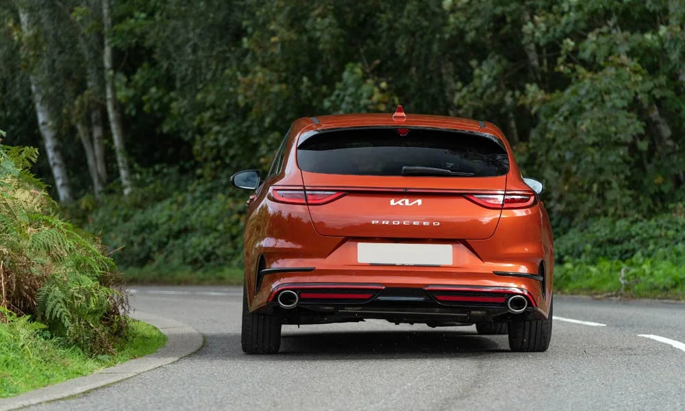 Фото KIA ProCeed (2024) — вид сзади, фото 6. Оранжевый кузов сзади — фонари и бампер определяют ночной образ модели. Светодиодная полоса или раздельные секции — задняя оптика стала главным украшением кормы KIA ProCeed (2024) — вид сзади, фото 6