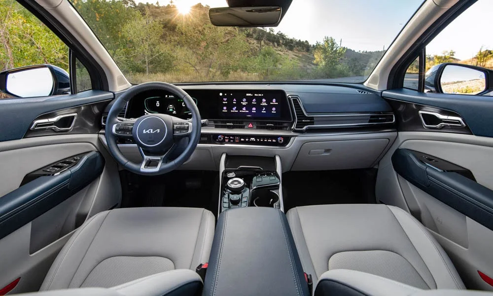 Фото KIA Sportage (2022) — интерьер. Общий план салона: архитектура панели, консоль и кресла. Уровень отделки читается по стыкам панелей и мягким поверхностям в зонах касания KIA Sportage (2022) — интерьер
