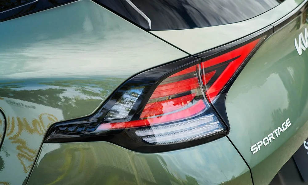 Фото KIA Sportage (2022) — вид сзади, фото 4. Линия крыши, стойки и задняя дверь в зелёном исполнении. Насадки выхлопа или их имитация внизу бампера различают версии KIA Sportage (2022) — вид сзади, фото 4