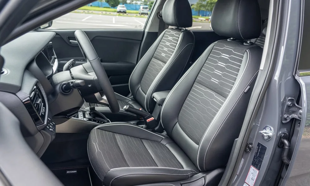 Фото KIA Stonic — передние сиденья. Водительское и пассажирское кресла: обивка из перфорированной коже, профиль с боковой поддержкой. Регулировки с памятью возвращают кресло под водителя одним нажатием — у версий с электроприводом KIA Stonic — передние сиденья