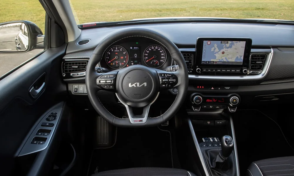Фото KIA Stonic — руль. Обшивка обода и компоновка спиц крупным планом. Правильная посадка: руки на «9 и 3», приборы читаются поверх обода KIA Stonic — руль