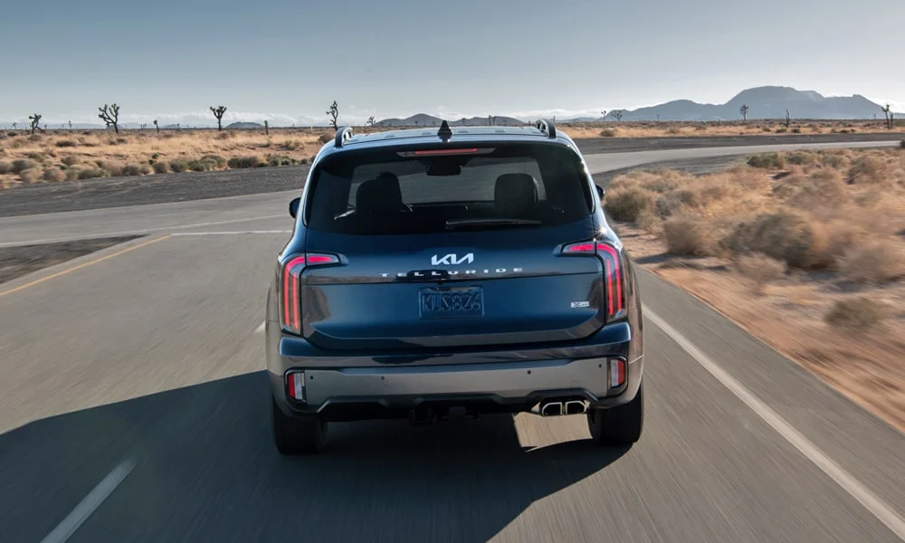 Фото KIA Telluride (2024) — вид сзади, фото 3. Корма в синем цвете: графика фонарей и пластика пятой двери. Светодиодная полоса или раздельные секции — задняя оптика стала главным украшением кормы KIA Telluride (2024) — вид сзади, фото 3