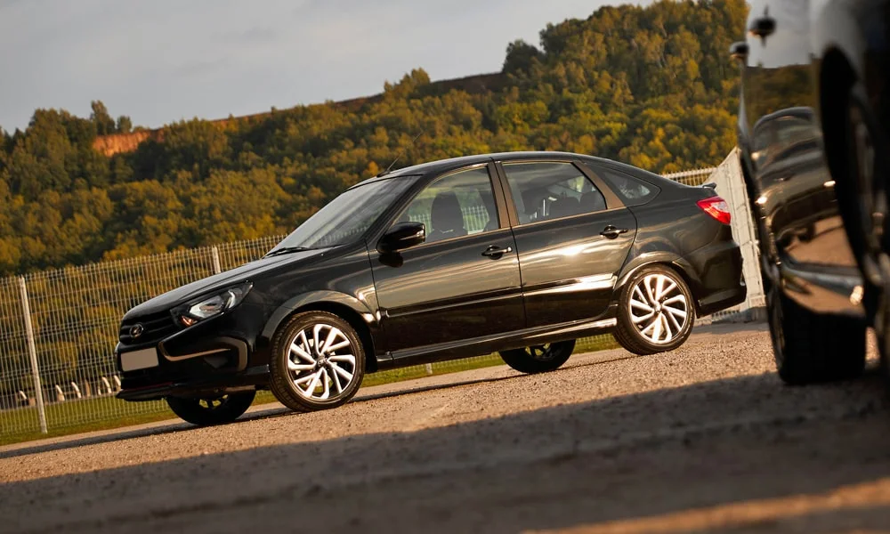 Фото LADA Granta Sportline Лифтбек (2023) — вид сбоку, фото 3. Сбоку читаются линия остекления и характер выштамповок на чёрном кузове. Длинная база — простор второго ряда; короткие свесы упрощают парковку LADA Granta Sportline Лифтбек (2023) — вид сбоку, фото 3