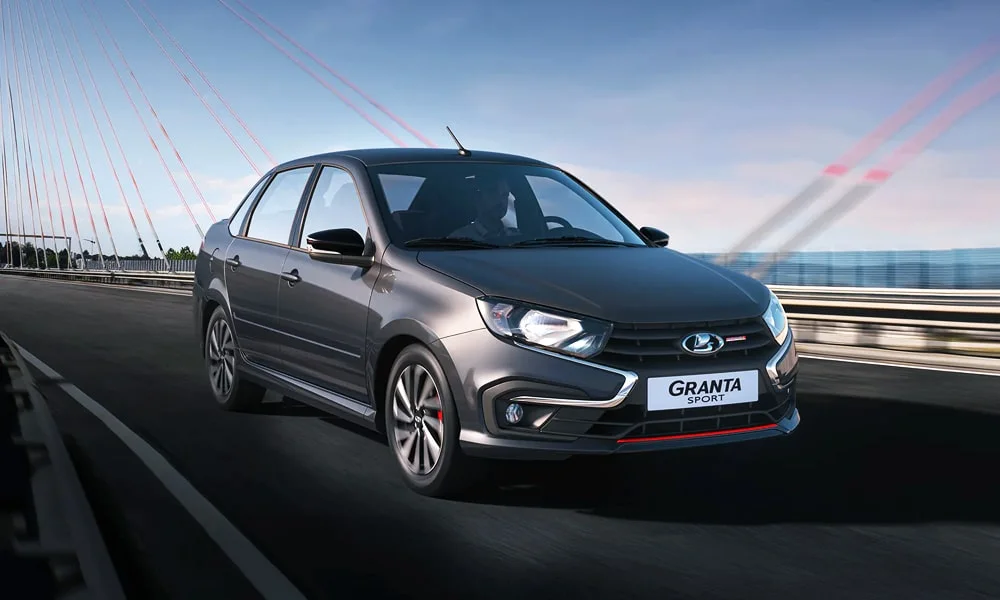 Фото LADA Granta Sport (2023) — вид спереди, фото 6. Кузов в сером цвете: рисунок оптики и решётки задаёт узнаваемое «лицо» модели. Рисунок ходовых огней — подпись модели, по нему её узнают в потоке LADA Granta Sport (2023) — вид спереди, фото 6