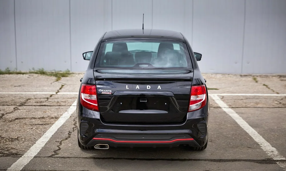 Фото LADA Granta Sport (2023) — вид сзади, фото 3. Чёрный кузов сзади — фонари и бампер определяют ночной образ модели. Светодиодная полоса или раздельные секции — задняя оптика стала главным украшением кормы LADA Granta Sport (2023) — вид сзади, фото 3