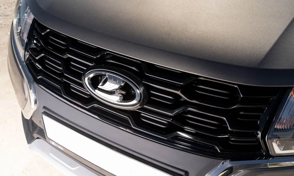 Фото LADA Largus Cross — решётка радиатора. Фирменный рисунок облицовки — визитная карточка марки. Активные жалюзи за решёткой закрываются на трассе ради аэродинамики — есть у ряда моделей LADA Largus Cross — решётка радиатора