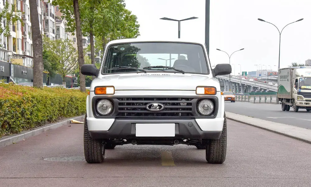 Фото LADA Niva Legend — вид спереди, фото 2. Передок в белом исполнении — крупная светотехника и выразительный бампер. Рисунок ходовых огней — подпись модели, по нему её узнают в потоке LADA Niva Legend — вид спереди, фото 2