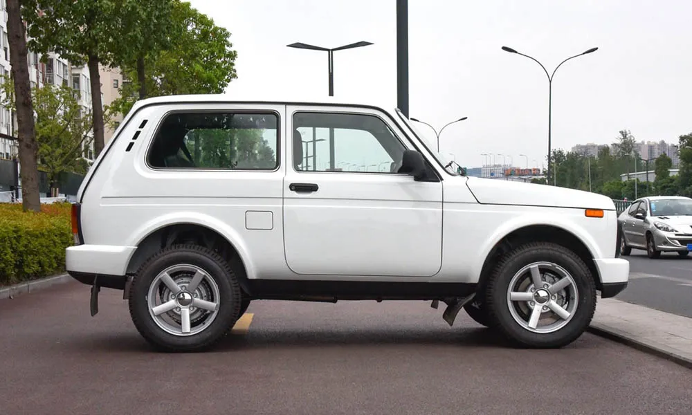 Фото LADA Niva Legend — вид сбоку, фото 2. Профиль кузова: колёсная база, свесы и линия остекления. Хромированные или чёрные молдинги окон отличают комплектации LADA Niva Legend — вид сбоку, фото 2