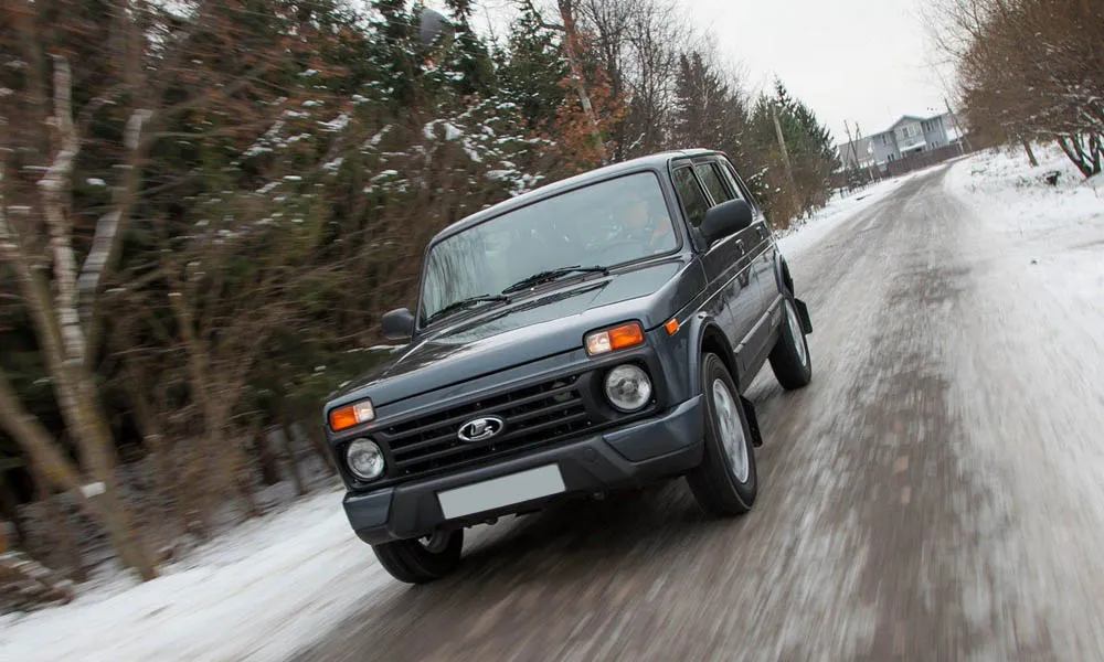 Фото LADA Niva Legend — вид спереди, фото 17. Чёрный кузов, строгая симметрия оптики — базовый ракурс знакомства с дизайном. Рисунок ходовых огней — подпись модели, по нему её узнают в потоке LADA Niva Legend — вид спереди, фото 17