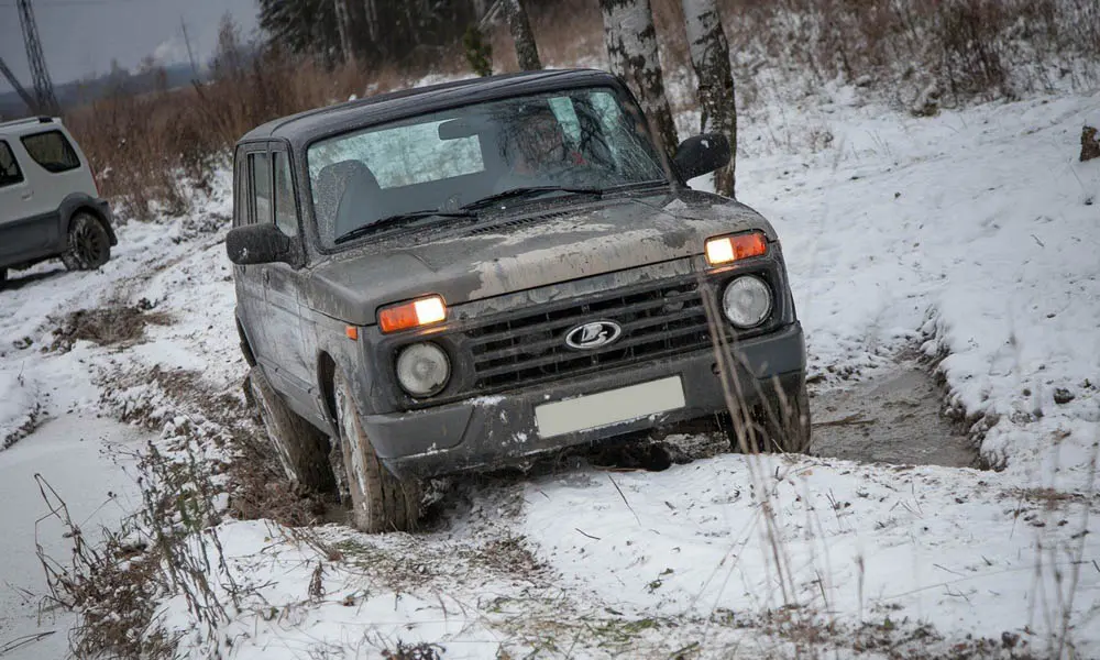 Фото LADA Niva Legend — вид спереди, фото 18. Кузов в сером цвете: рисунок оптики и решётки задаёт узнаваемое «лицо» модели. Рисунок ходовых огней — подпись модели, по нему её узнают в потоке LADA Niva Legend — вид спереди, фото 18