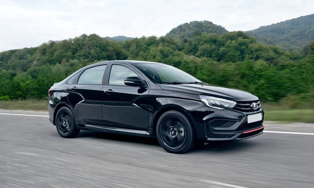 Фото LADA Vesta Sportline (2023) — вид спереди, фото 6. Чёрный кузов, строгая симметрия оптики — базовый ракурс знакомства с дизайном. Рисунок ходовых огней — подпись модели, по нему её узнают в потоке LADA Vesta Sportline (2023) — вид спереди, фото 6