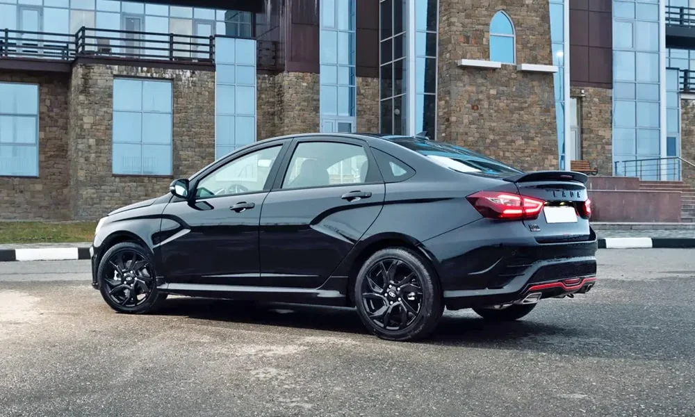Фото LADA Vesta Sportline (2023) — вид сзади. Корма в чёрном цвете: графика фонарей и пластика пятой двери LADA Vesta Sportline (2023) — вид сзади