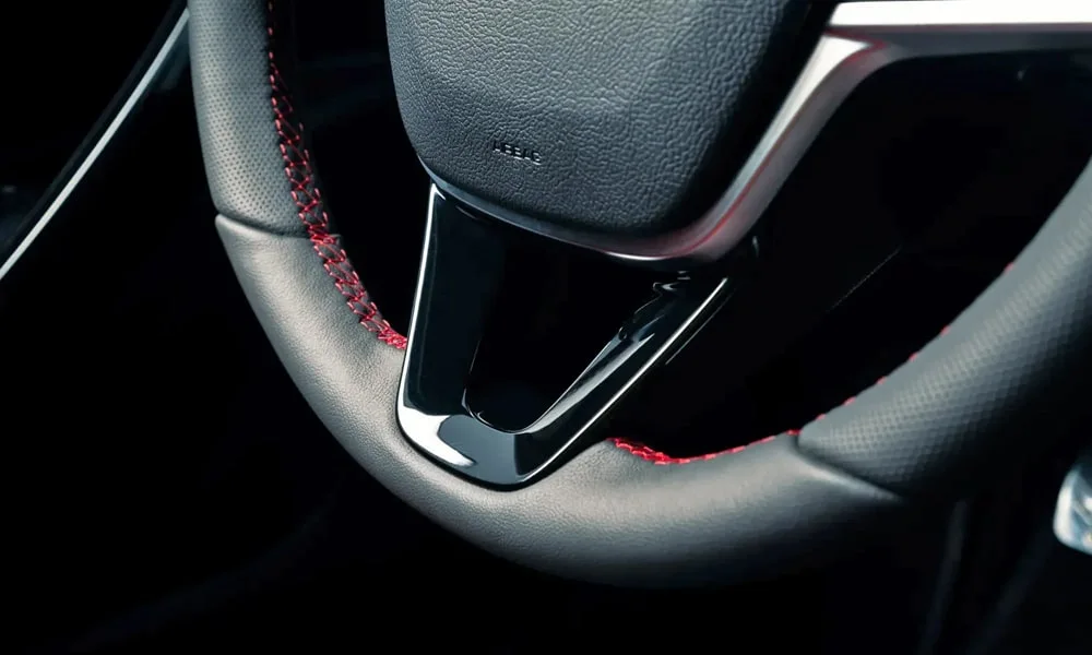 Фото LADA Vesta Sportline (2023) — руль, фото 3. Обшивка обода и компоновка спиц крупным планом. Клавиши на спицах управляют медиа, круизом и ассистентами — руки остаются на руле LADA Vesta Sportline (2023) — руль, фото 3