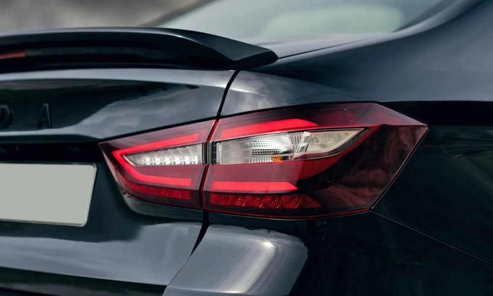 Фото LADA Vesta Sportline (2023) — задние фонари. Графика секций крупным планом — ночная подпись модели. Динамические поворотники с бегущей индикацией встречаются в старших комплектациях LADA Vesta Sportline (2023) — задние фонари
