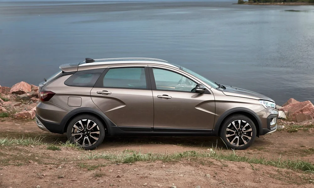 Фото LADA Vesta SW Cross (2023) — вид сбоку, фото 2. Сбоку читаются линия остекления и характер выштамповок на коричневом кузове LADA Vesta SW Cross (2023) — вид сбоку, фото 2