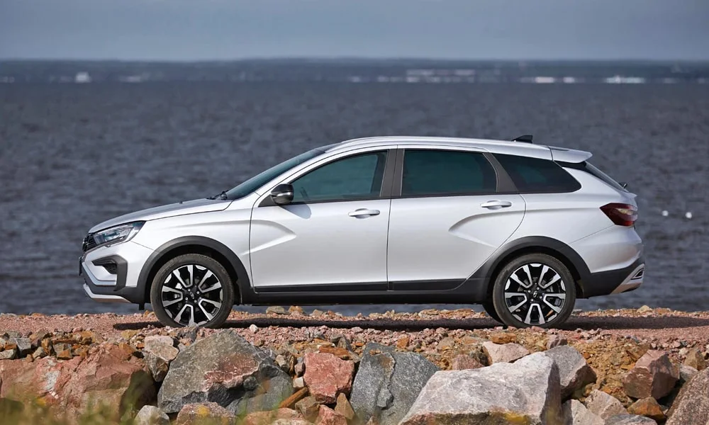 Фото LADA Vesta SW Cross (2023) — вид сбоку, фото 3. Сбоку читаются линия остекления и характер выштамповок на серебристом кузове. Длинная база — простор второго ряда; короткие свесы упрощают парковку LADA Vesta SW Cross (2023) — вид сбоку, фото 3
