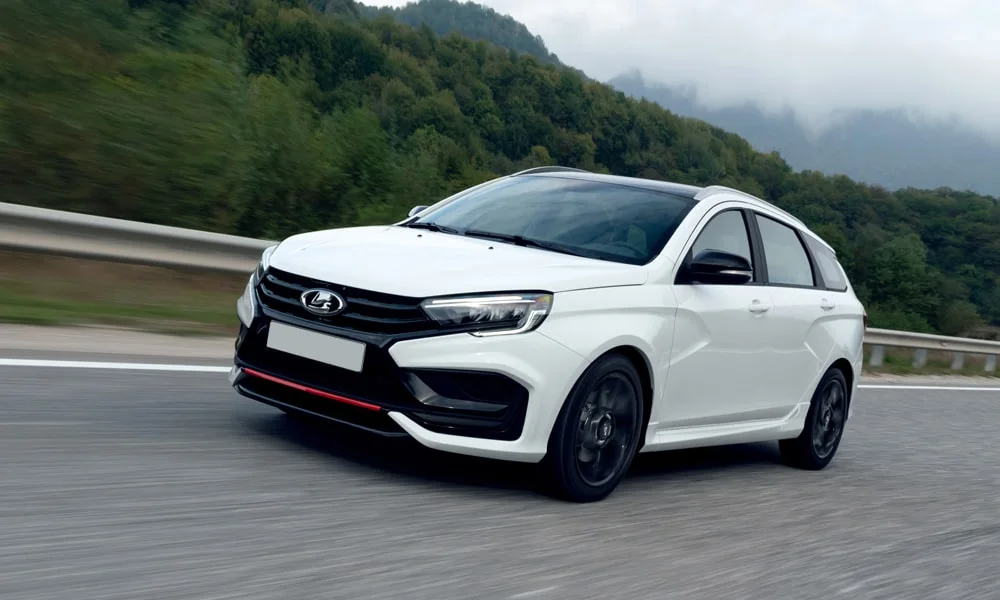 Фото LADA Vesta SW Sportline — вид спереди, фото 8. Передок в белом исполнении — крупная светотехника и выразительный бампер. Рисунок ходовых огней — подпись модели, по нему её узнают в потоке LADA Vesta SW Sportline — вид спереди, фото 8