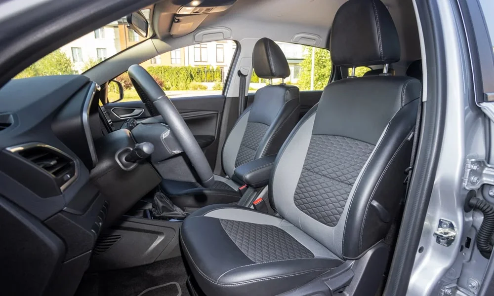 Фото LADA Vesta SW (2023) — передние сиденья. Водительское и пассажирское кресла: обивка из перфорированной коже, профиль с боковой поддержкой. Выраженная боковая поддержка держит в поворотах LADA Vesta SW (2023) — передние сиденья