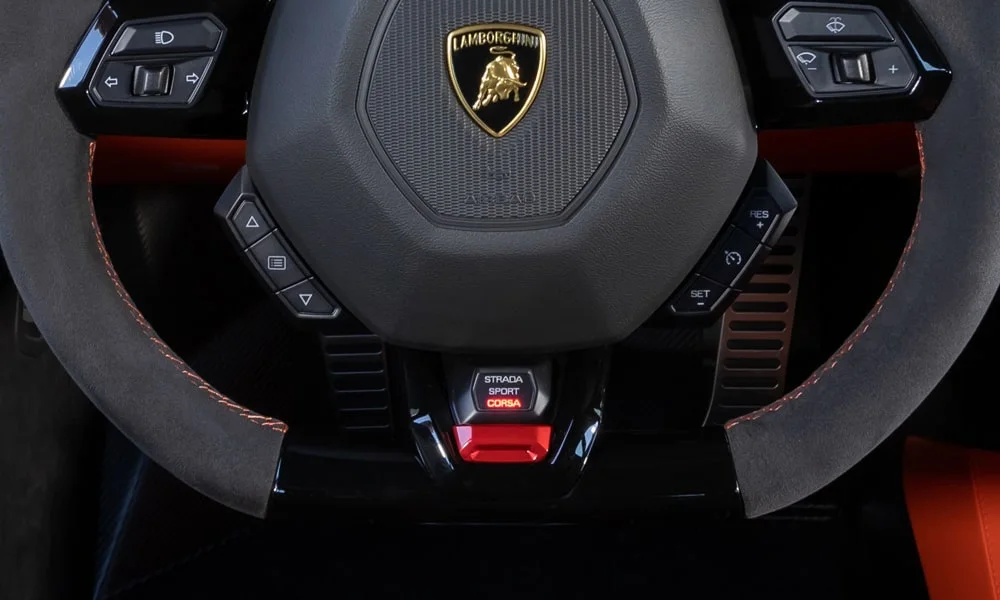 Фото Lamborghini Huracan — руль, фото 3. Обшивка обода и компоновка спиц крупным планом. Клавиши на спицах управляют медиа, круизом и ассистентами — руки остаются на руле Lamborghini Huracan — руль, фото 3