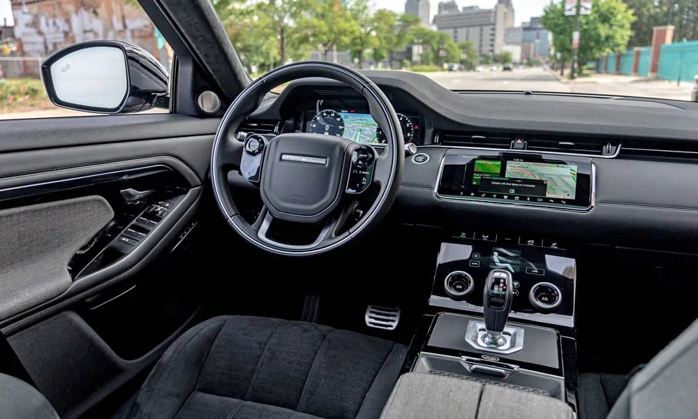 Фото Land Rover Land Rover Range Rover Evoque — передняя панель. Панель в тёмной отделке — видна компоновка экранов и органов управления. Мягкие материалы верхнего яруса и вставки задают уровень интерьера Land Rover Land Rover Range Rover Evoque — передняя панель