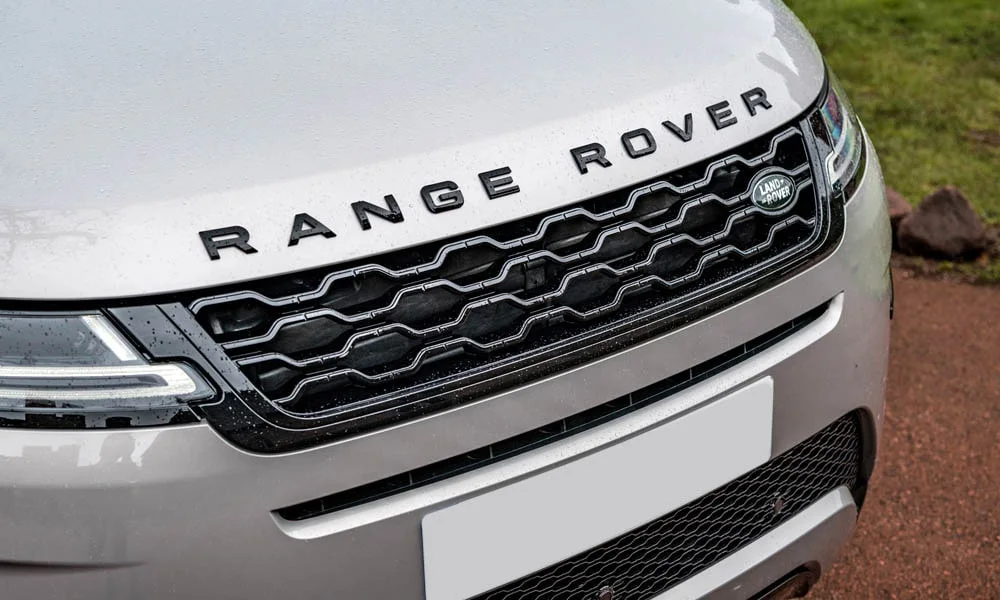 Фото Land Rover Land Rover Range Rover Evoque — решётка радиатора. Фирменный рисунок облицовки — визитная карточка марки. Активные жалюзи за решёткой закрываются на трассе ради аэродинамики — есть у ряда моделей Land Rover Land Rover Range Rover Evoque — решётка радиатора