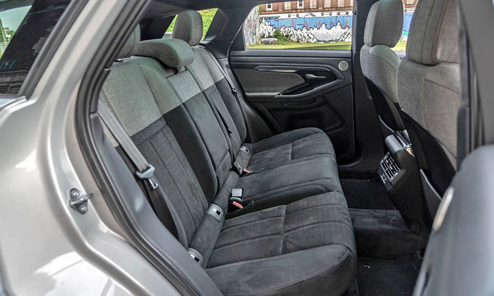Фото Land Rover Land Rover Range Rover Evoque — задние сиденья. Второй ряд: профиль дивана, подголовники и обивка из алькантаре. Спинки складываются под длинные грузы у большинства версий Land Rover Land Rover Range Rover Evoque — задние сиденья